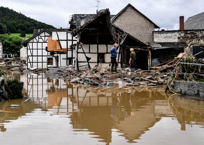Locuitorii inspectează joi o casă prăbușită după revărsarea râului Ahr în Schulde, Germania.