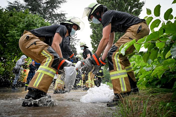 Pompierii și lucrătorii de ajutor muta saci de nisip împotriva apelor în creștere în râul Dussel, în D & # xfc;  sseldorf Grafenberg, Germania joi.