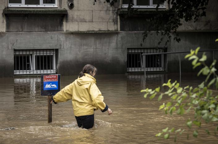 O femeie care se confruntă cu apele inundațiilor din # xe8 a lui Lee;  General Electric, Belgia joi.
