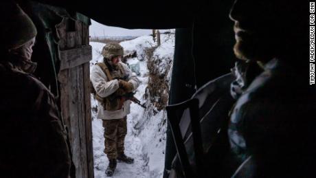 Soldații ucraineni aflați într-un șanț pe linia frontului lângă separatiștii pro-ruși se adăpostesc de frigul amar. 