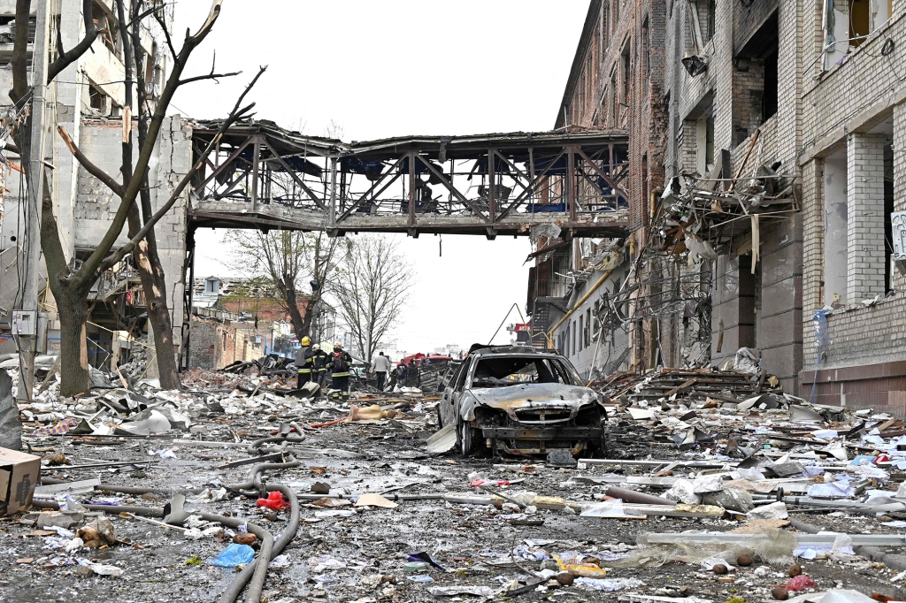 Salvatorii examinează resturile clădirilor distruse după bombardament, ucigând două persoane și rănind alte 18, potrivit Parchetului din regiunea Harkov, în orașul ucrainean Harkiv, pe 16 aprilie 2022.