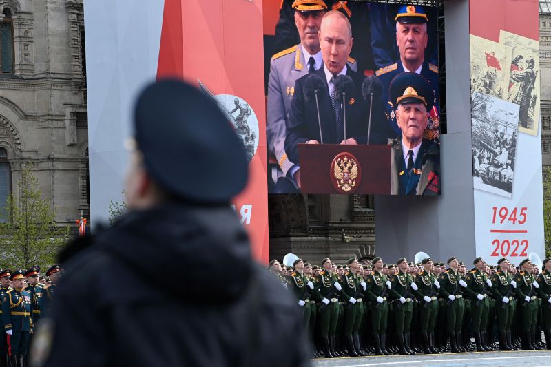 Un ecran îl arată pe președintele rus Vladimir Putin ținând un discurs în timp ce soldații aliniază Piața Roșie în timpul paradei militare de Ziua Victoriei de la Moscova, pe 9 mai.