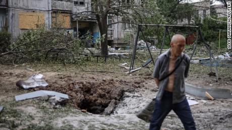 Un rezident local trece pe lângă un bloc de apartamente distrus într-o lovitură cu rachete, pe fondul invaziei Ucrainei de către Rusia, în Bakhmut, Ucraina, 13 iunie 2022. 