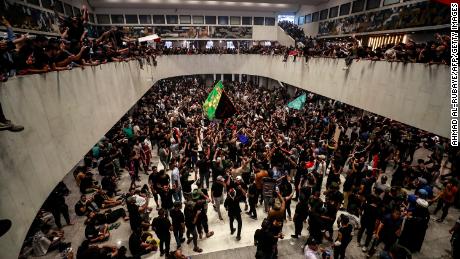 Protestatarii aplaudă după ce au intrat sâmbătă în parlamentul irakian.