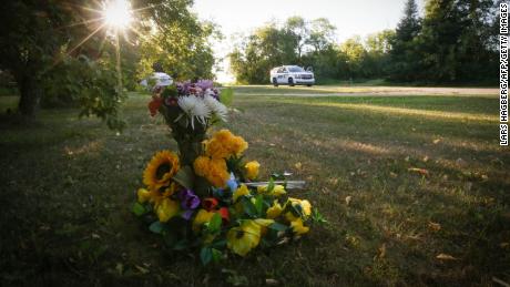 Flori stau în afara casei unde a fost găsită o victimă înjunghiată în Weldon, Saskatchewan.