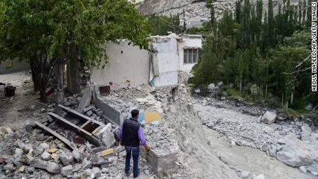 Un rezident local stă lângă casa lui distrusă în iunie, după ce o explozie a unui lac glaciar a provocat inundații catastrofale în satul Hassanabad din nordul Pakistanului. 